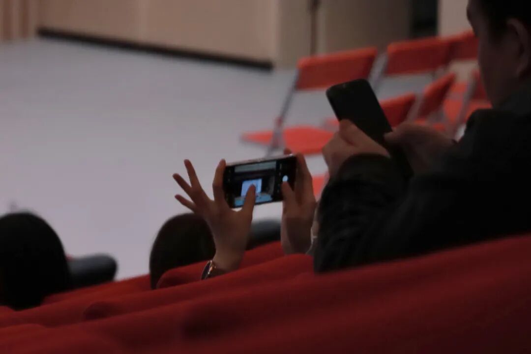 图：家长用手机拍照记录要点